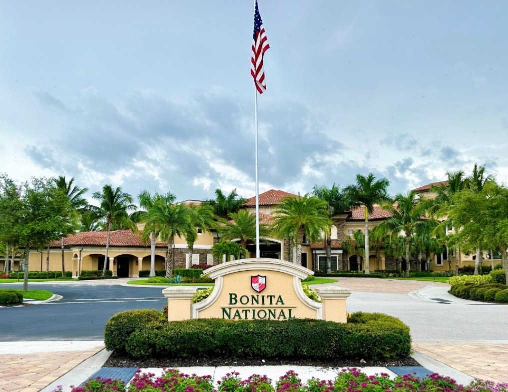 Bonita National Golf & Country Club entrance with monument sign, clubhouse, and flagpole in Bonita Springs, Florida
