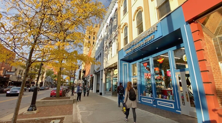 A downtown Ann Arbor street lined with storefronts and trees