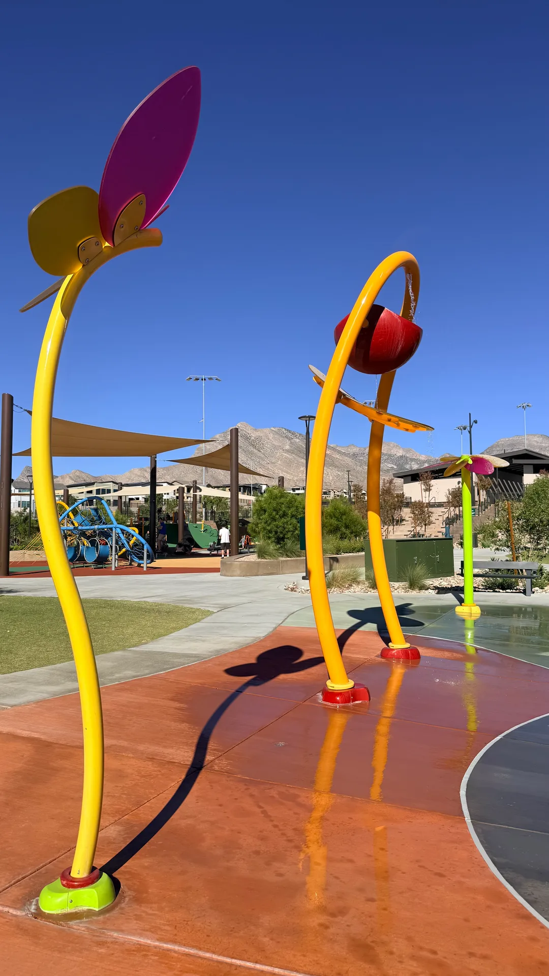 Splash pad with colorful flower-shaped water sprays in a Summerlin park