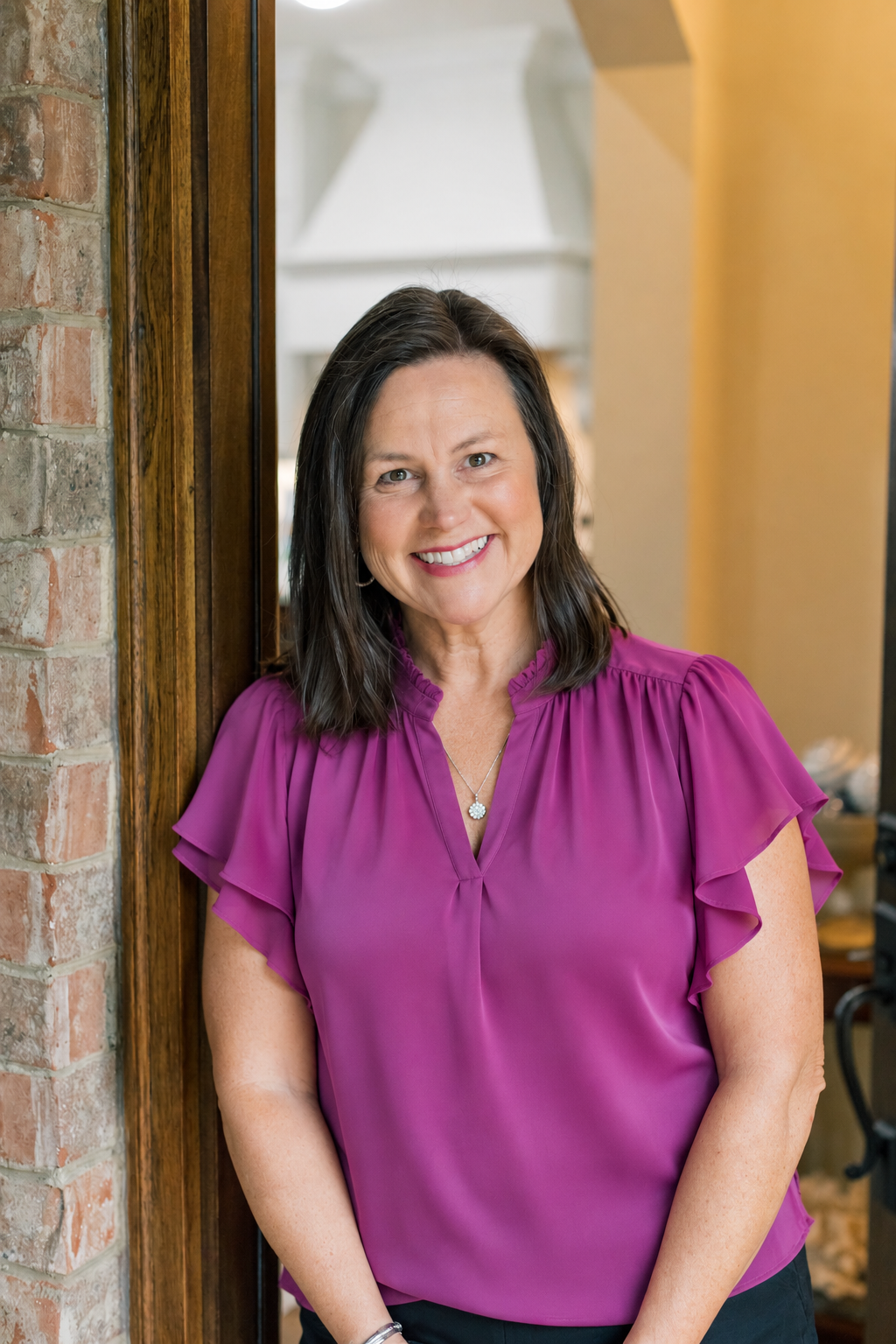 Rozi Dover leaning in a doorway with a warm smile