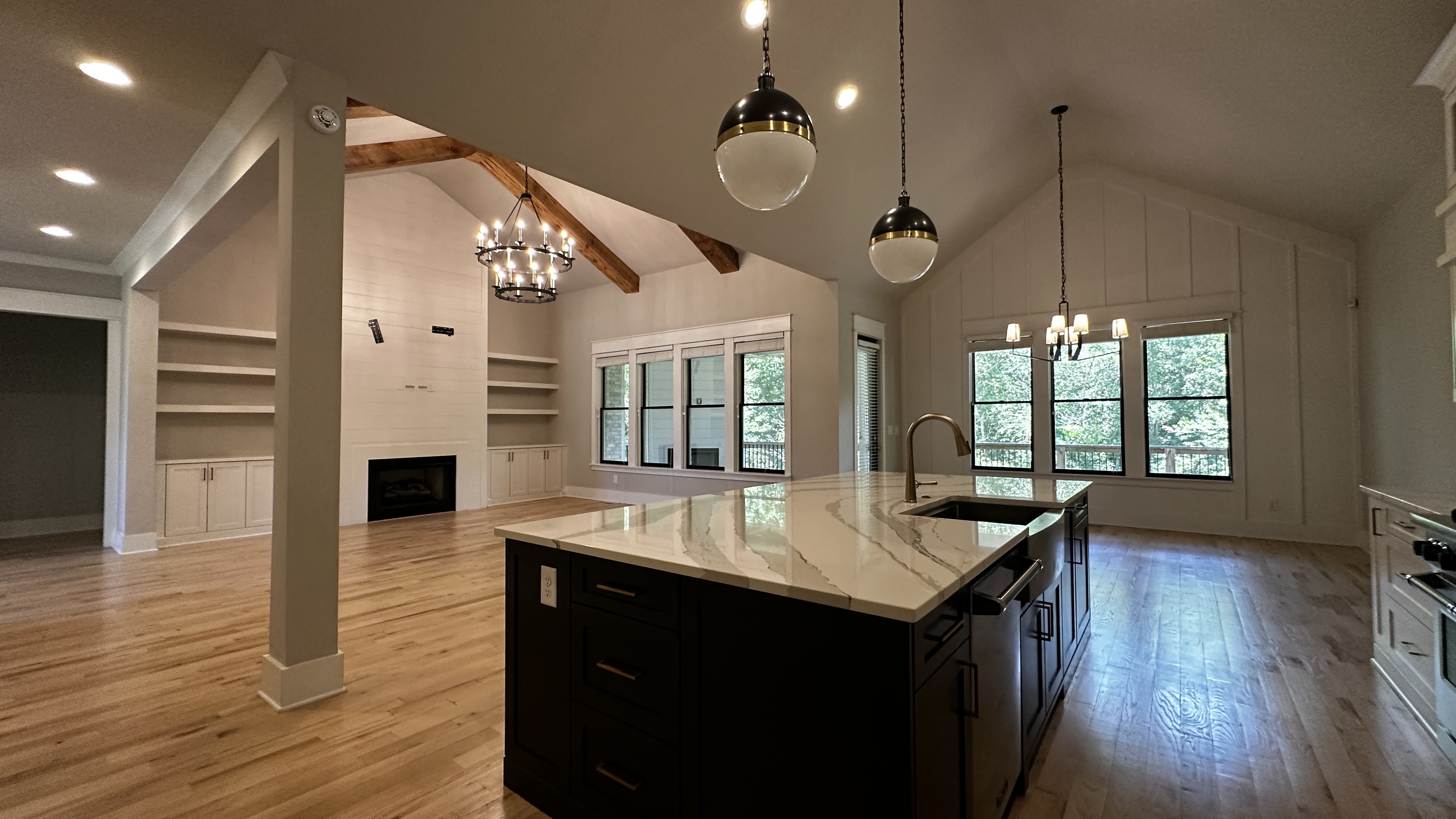 Open-concept living and kitchen at 5760 Lula Bridge Ct with vaulted ceilings and beams