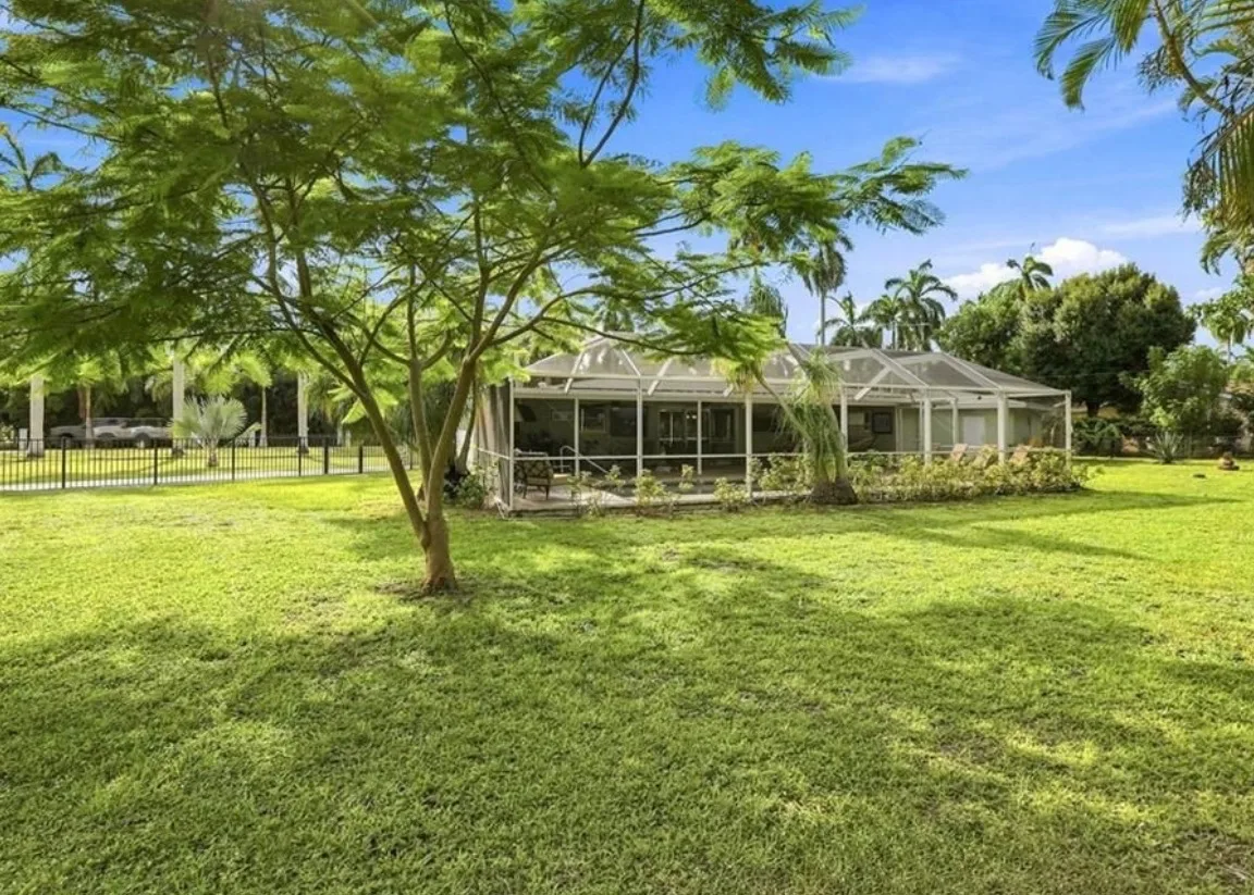 Screened pool with pool cage at 2741 McGregor Blvd — a classic Florida backyard with pool, deck, and mature landscaping