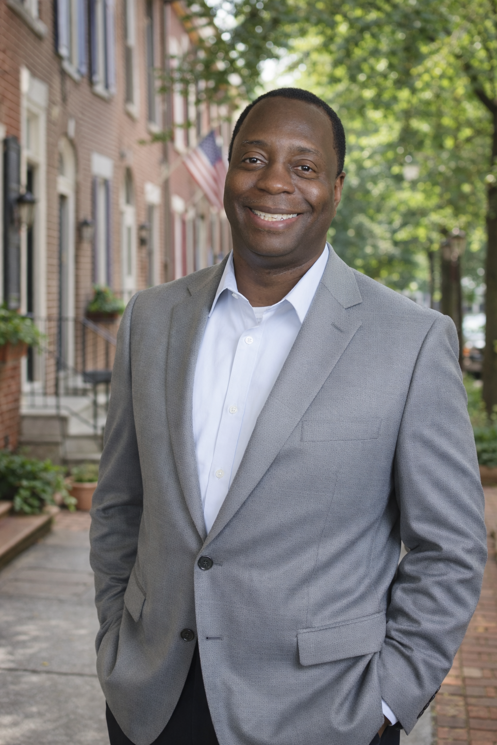 Andre Richardson in a grey blazer on a Philadelphia rowhouse street