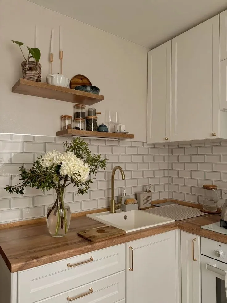 A bright, modern kitchen with white cabinetry, a large center island, and stainless steel appliances