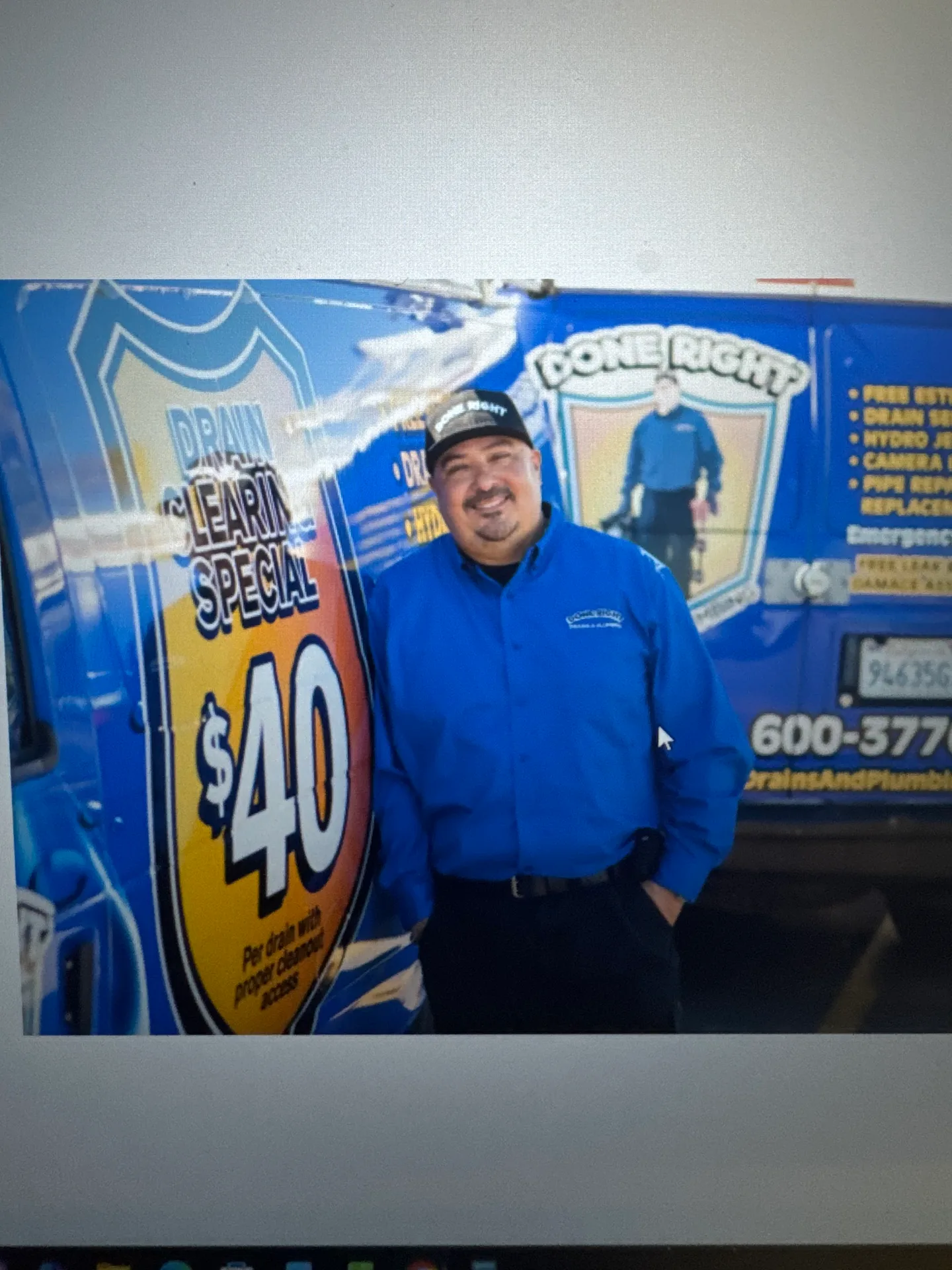 The owner of Done Right Drains And Plumbing standing beside the company van, with the family business's name on the door