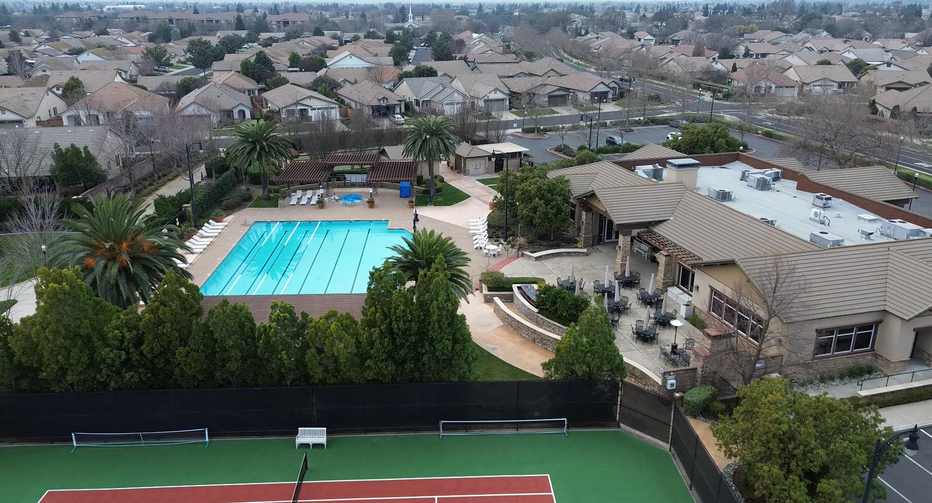 The clubhouse and pool at Del Webb Glenbrooke in Elk Grove, California, with loungers along the water