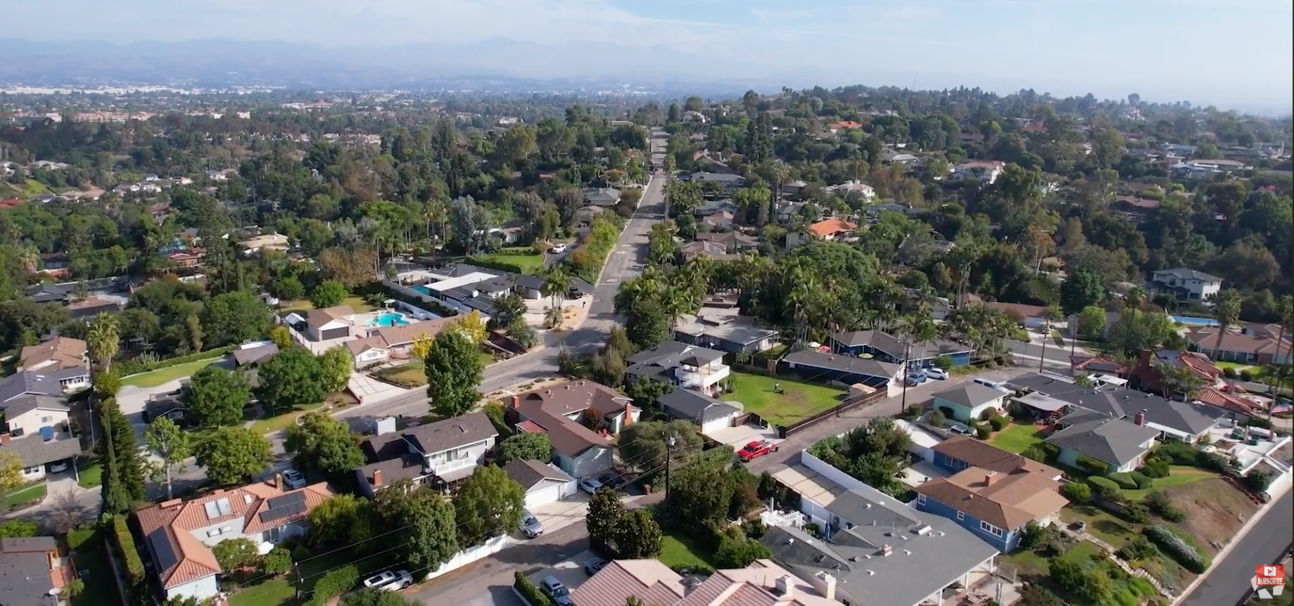 Aerial view of Fullerton Hills suburban neighborhood with mature trees, winding streets, and hills in the distance