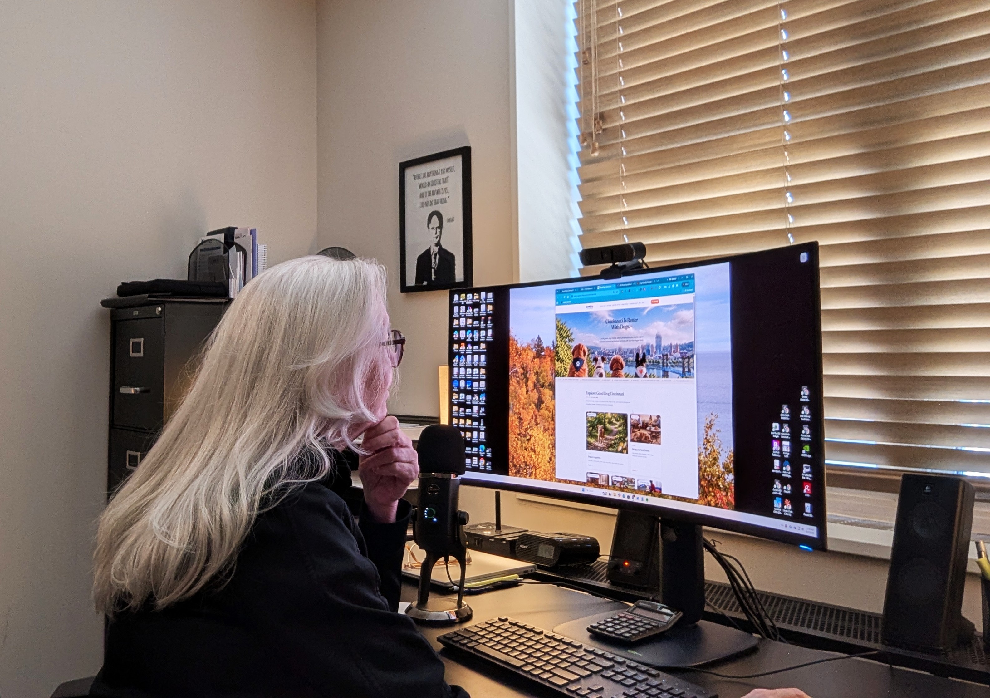 Chris Harris at work at her desk, with Good Dog Cincinnati open on her monitor, in her Greater Cincinnati office