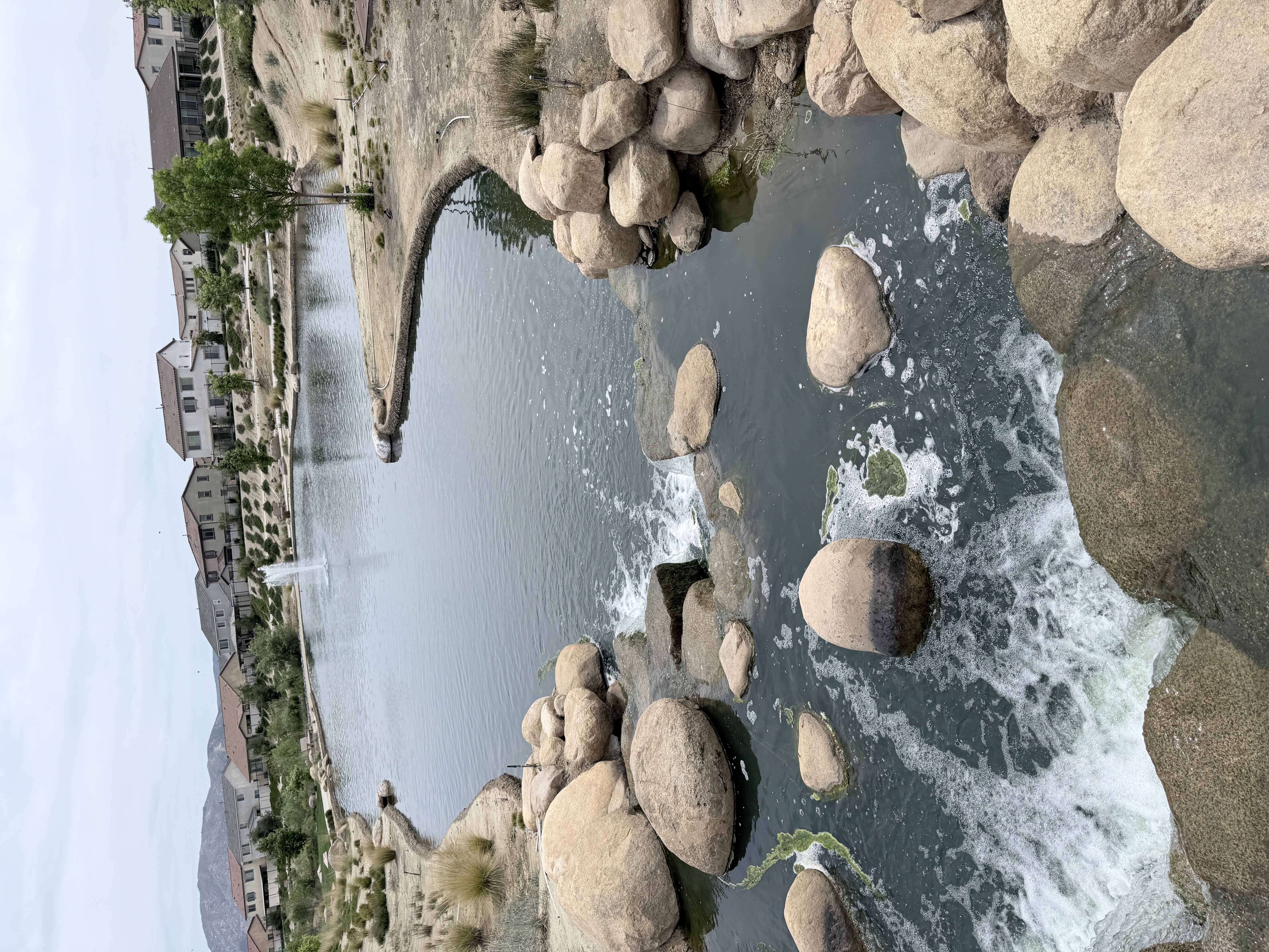 Beautiful Beaumont residential community with a pond, fountain, and Southern California foothills in the background