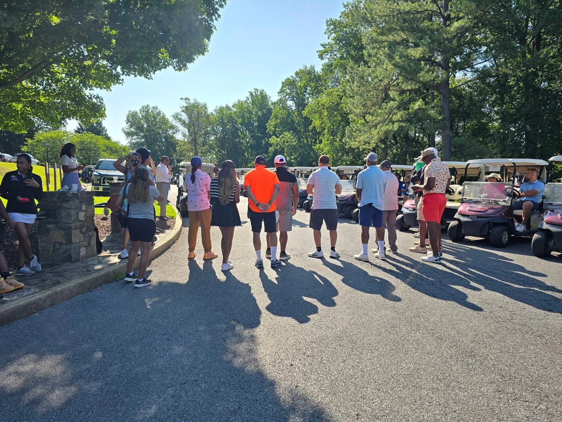 Groups of community members and business leaders socializing on the clubhouse lawn at the FORE the KIDS Golf Tournament