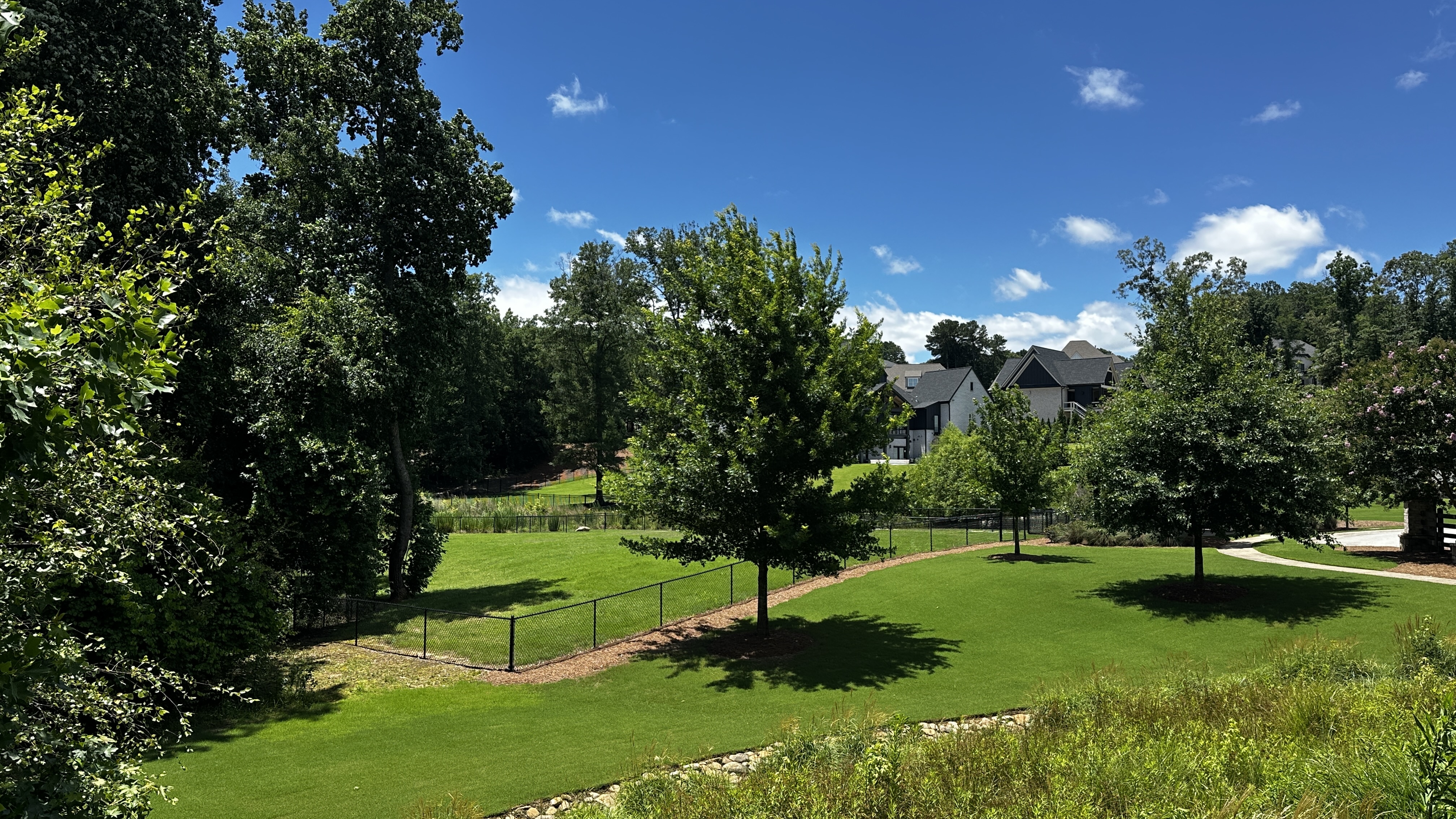 Covered Bridge dog park at Chateau Elan with picnic pavilion and benches near the fenced play areas