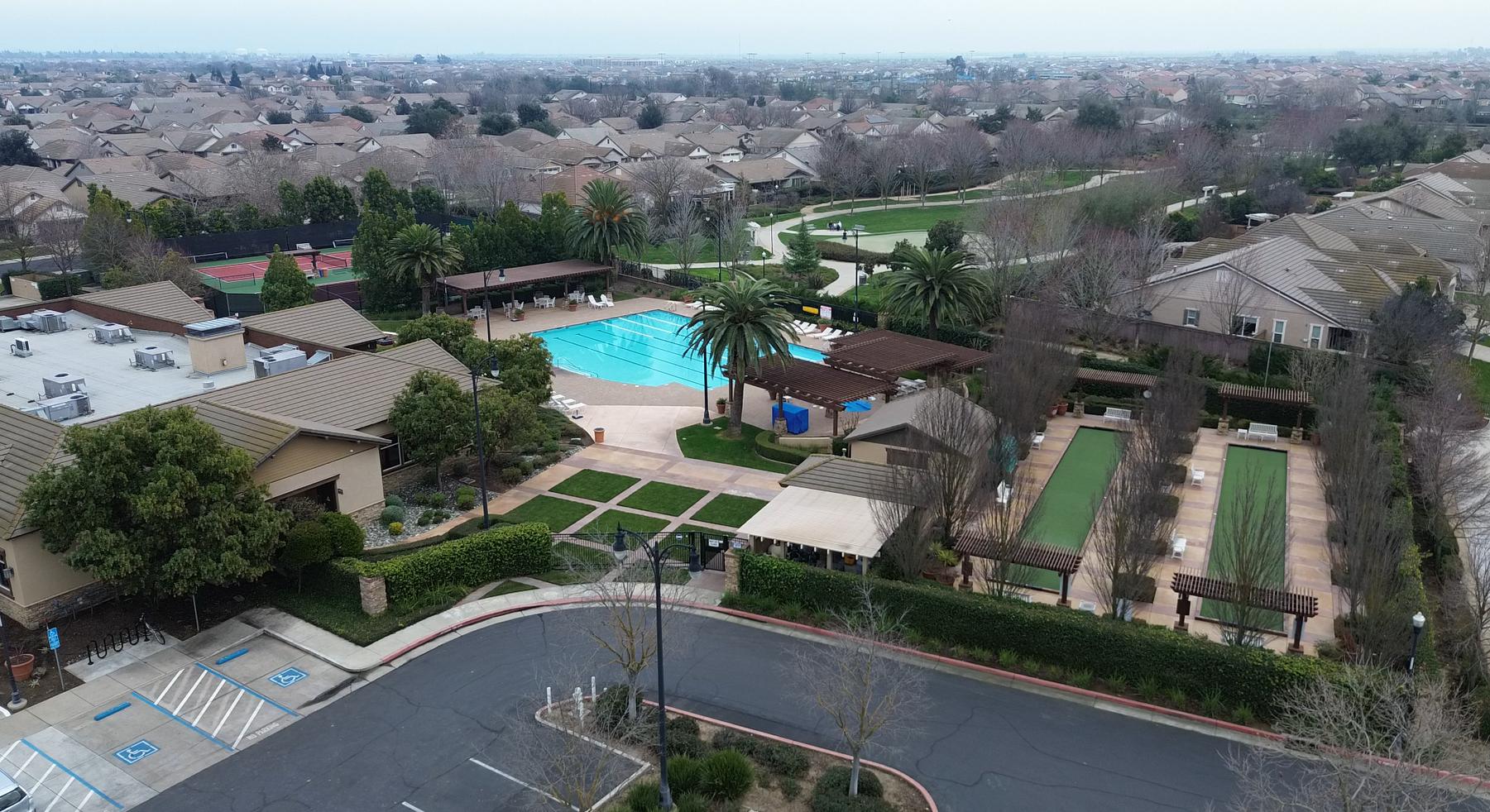 Aerial view over the Arbour Lodge, pool and bocce courts at Del Webb Glenbrooke in Elk Grove, with the pool at the center
