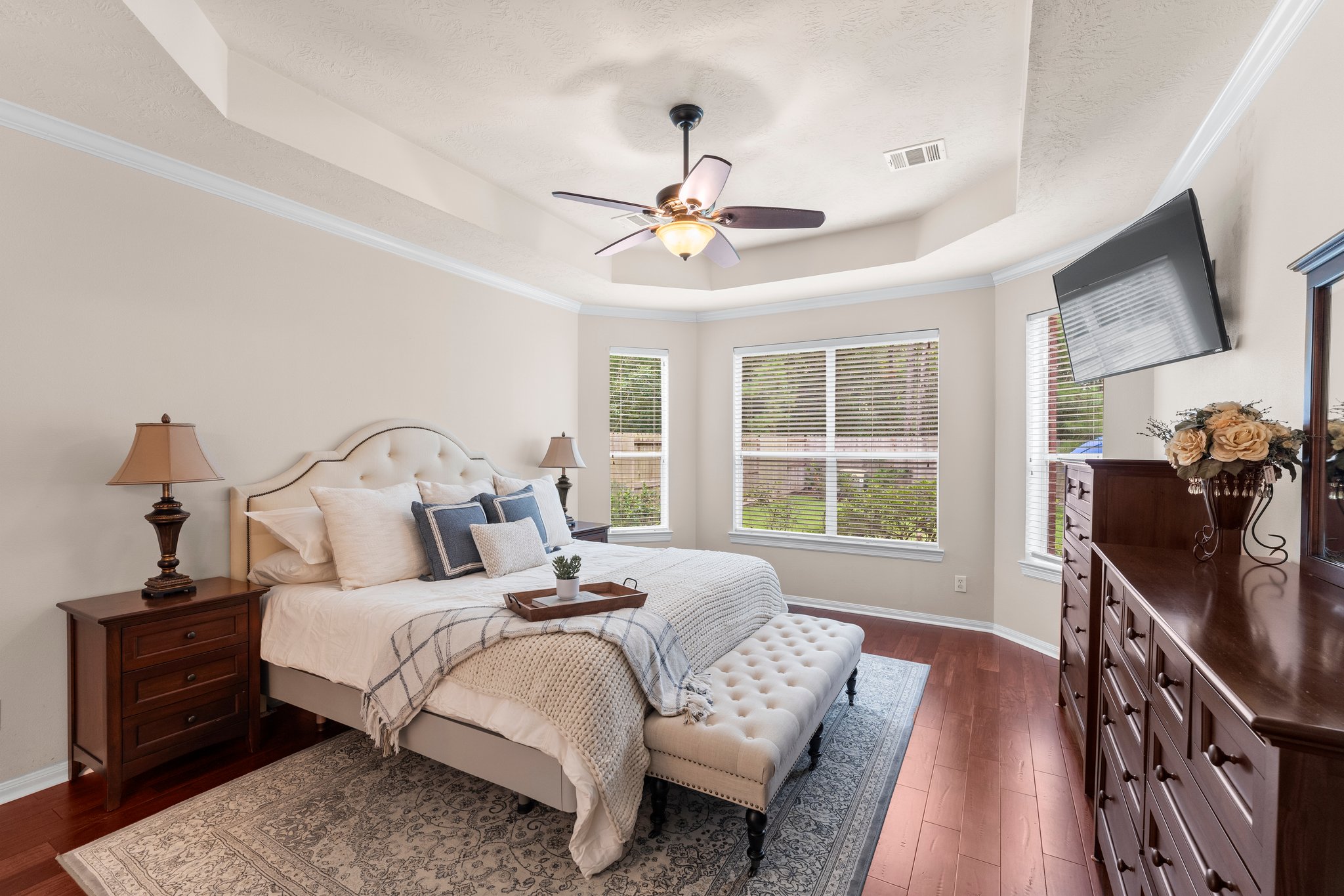 A bedroom with a tray ceiling, presented at its best in the listing media