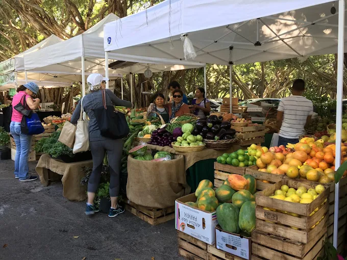 Colorful outdoor farmers market vendor stalls with tropical produce, artisan crafts, and local goods in Islamorada