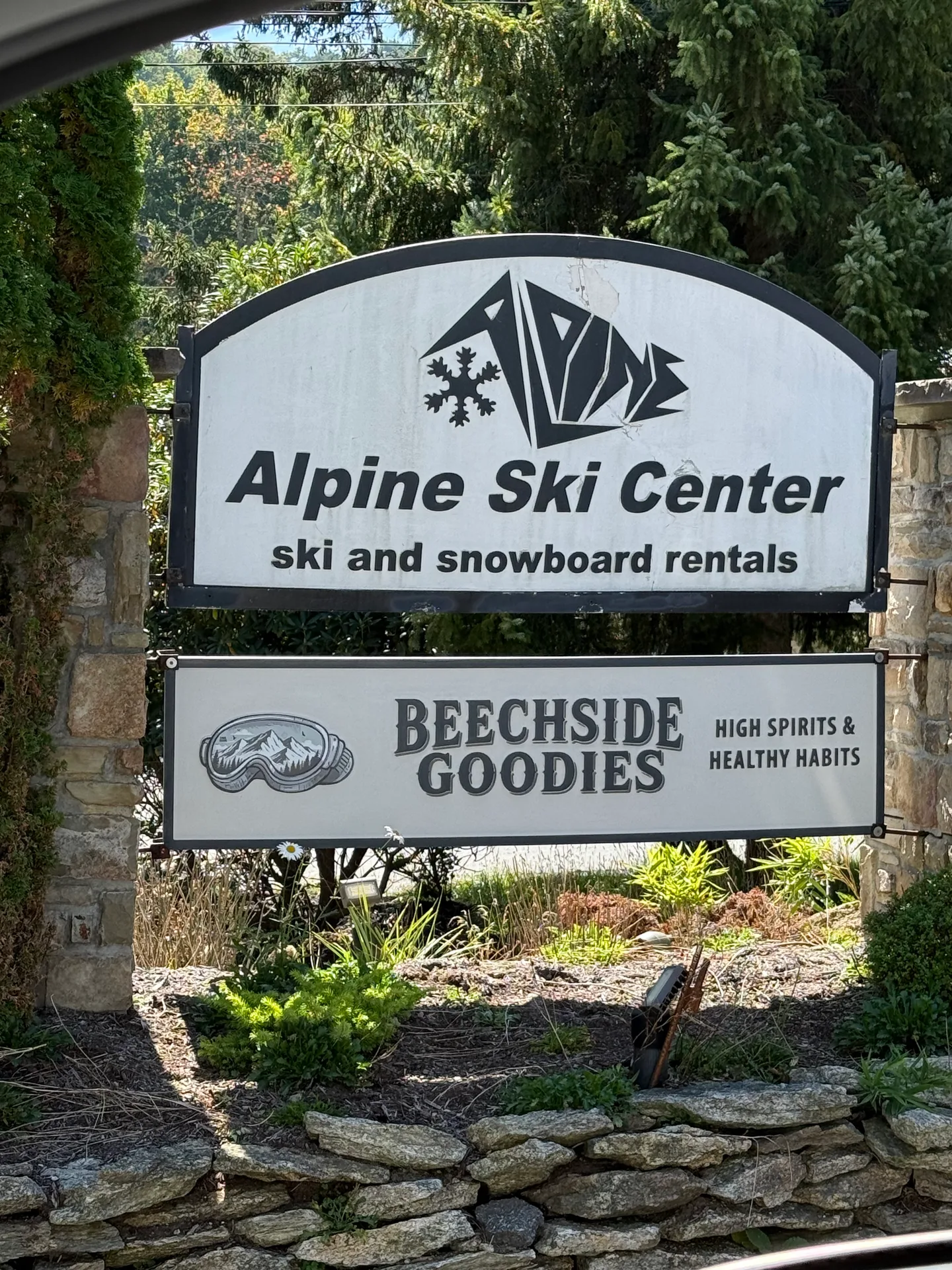 The Alpine Ski Center entrance sign at Beech Mountain, with the ski and snowboard rentals sign above the Beechside Goodies high spirits and healthy habits sign