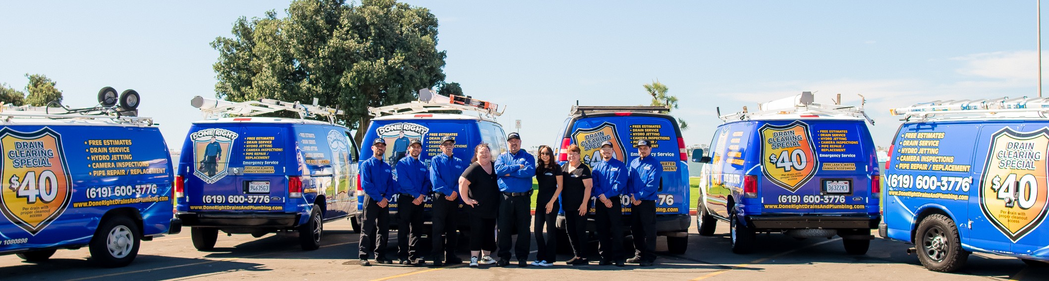 The Done Right Drains And Plumbing team standing together in front of the company vans