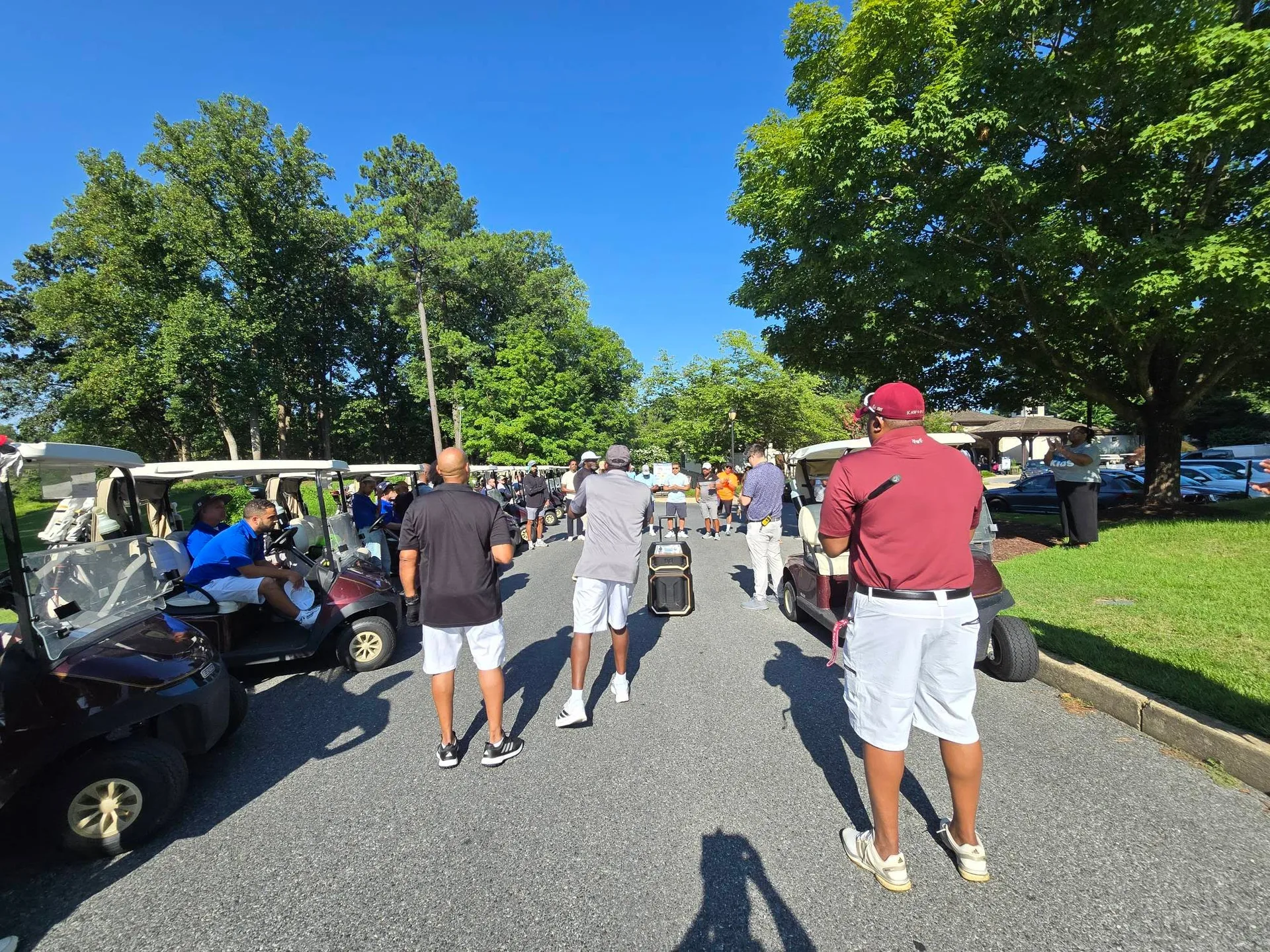 Golfers gathering with their carts at the FORE the KIDS Golf Tournament