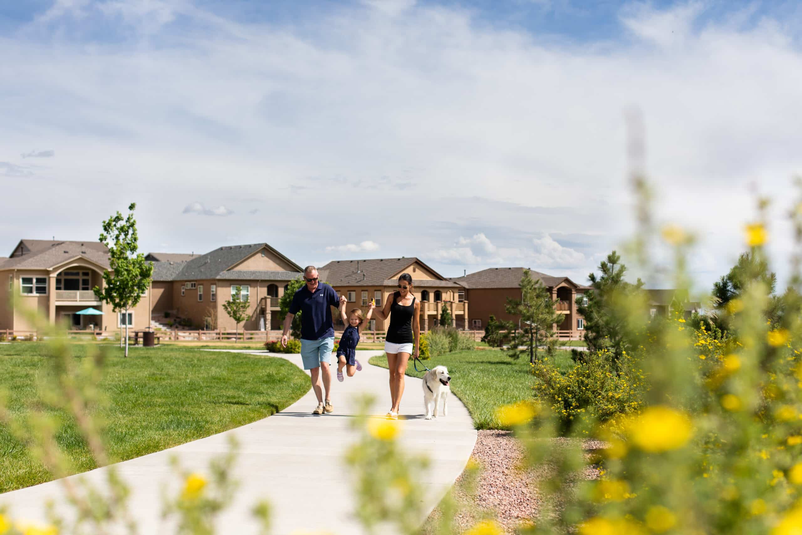 Community park with pavilion, fountain, and residents biking in a new construction neighborhood