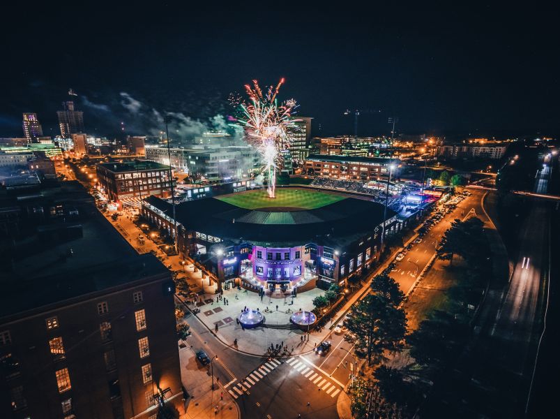 Fireworks bursting over the Durham Bulls Athletic Park baseball stadium at night in Downtown Durham