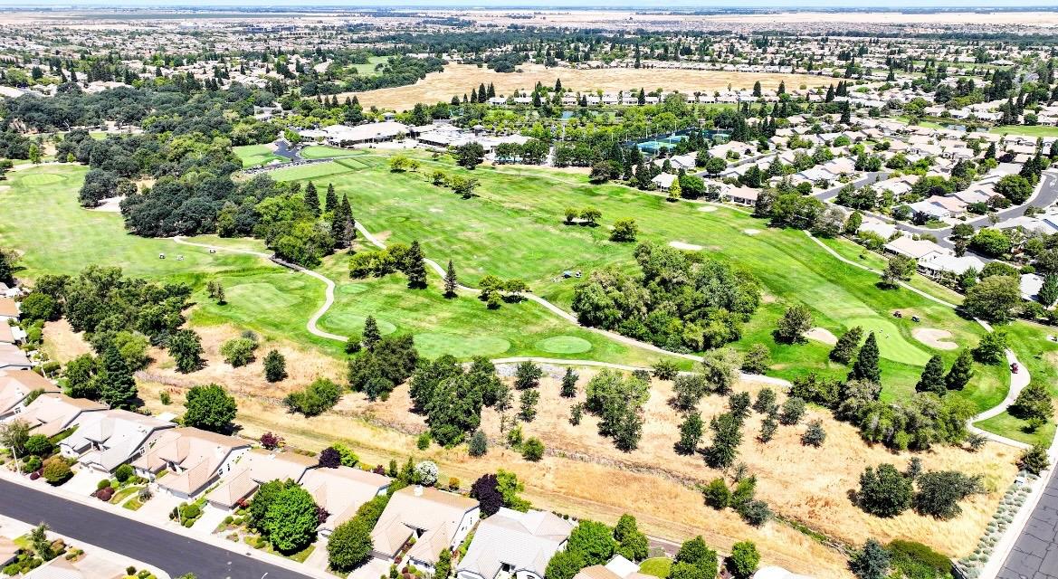 Aerial drone view of the golf course greens and surrounding homes at Sun City Roseville in Roseville, California