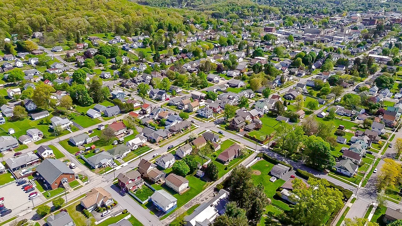 Aerial view of Indiana, PA showing vibrant green trees and a charming residential neighborhood