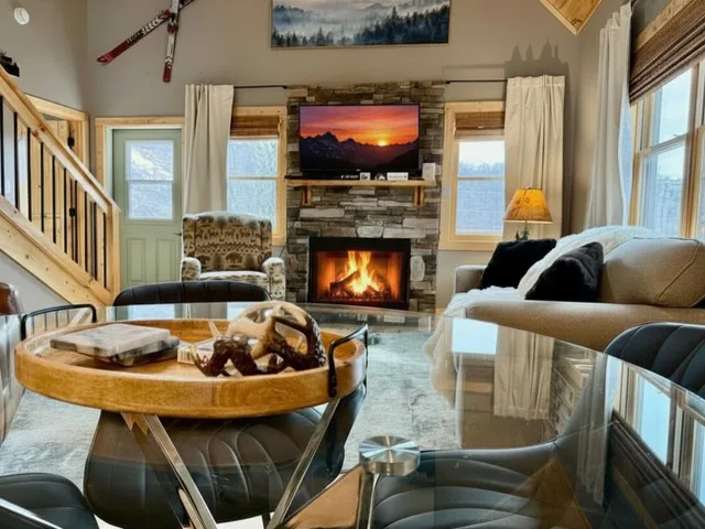 The den with a fireplace and skis on the wall