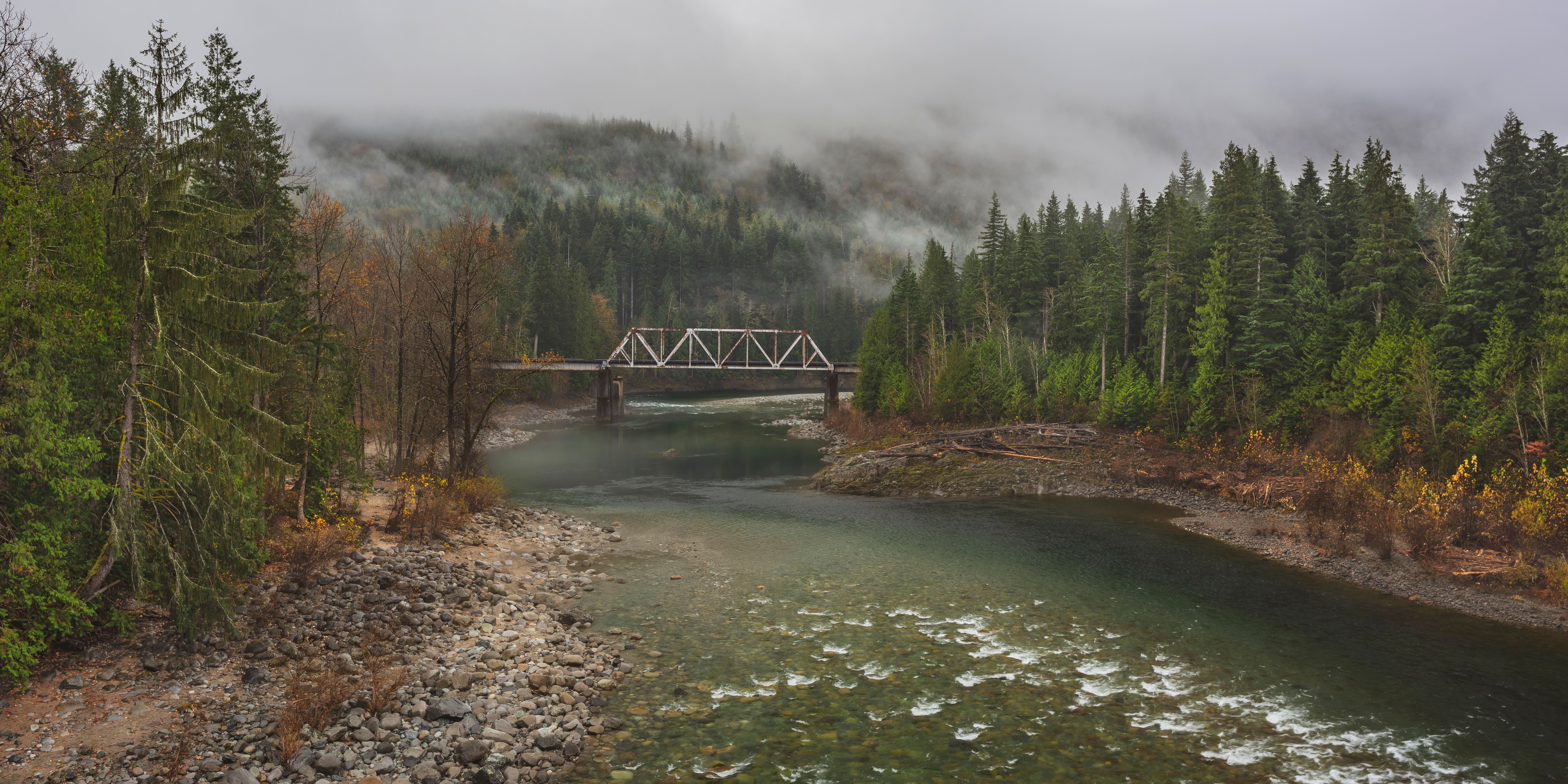 The Skykomish River near Gold Bar, Washington, with a steel truss railway bridge crossing the water and Cascade foothills beyond