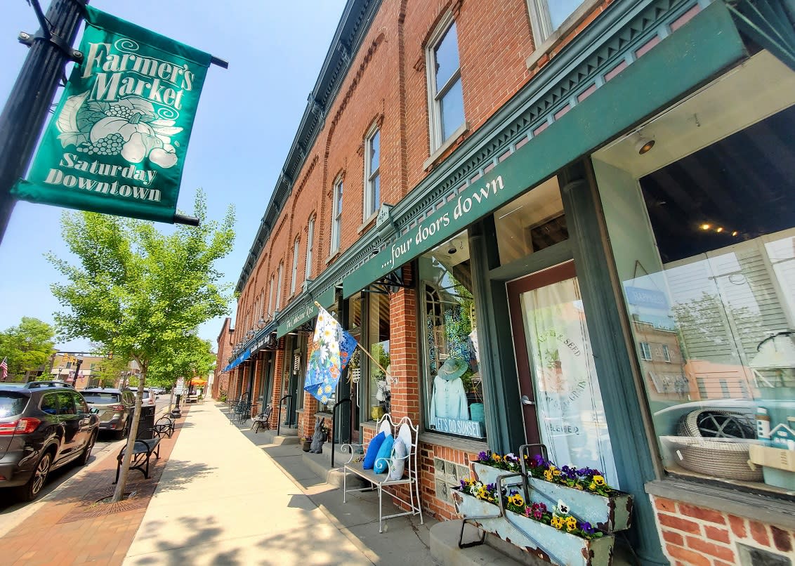 A downtown Saline street scene with storefronts and a tree-lined sidewalk