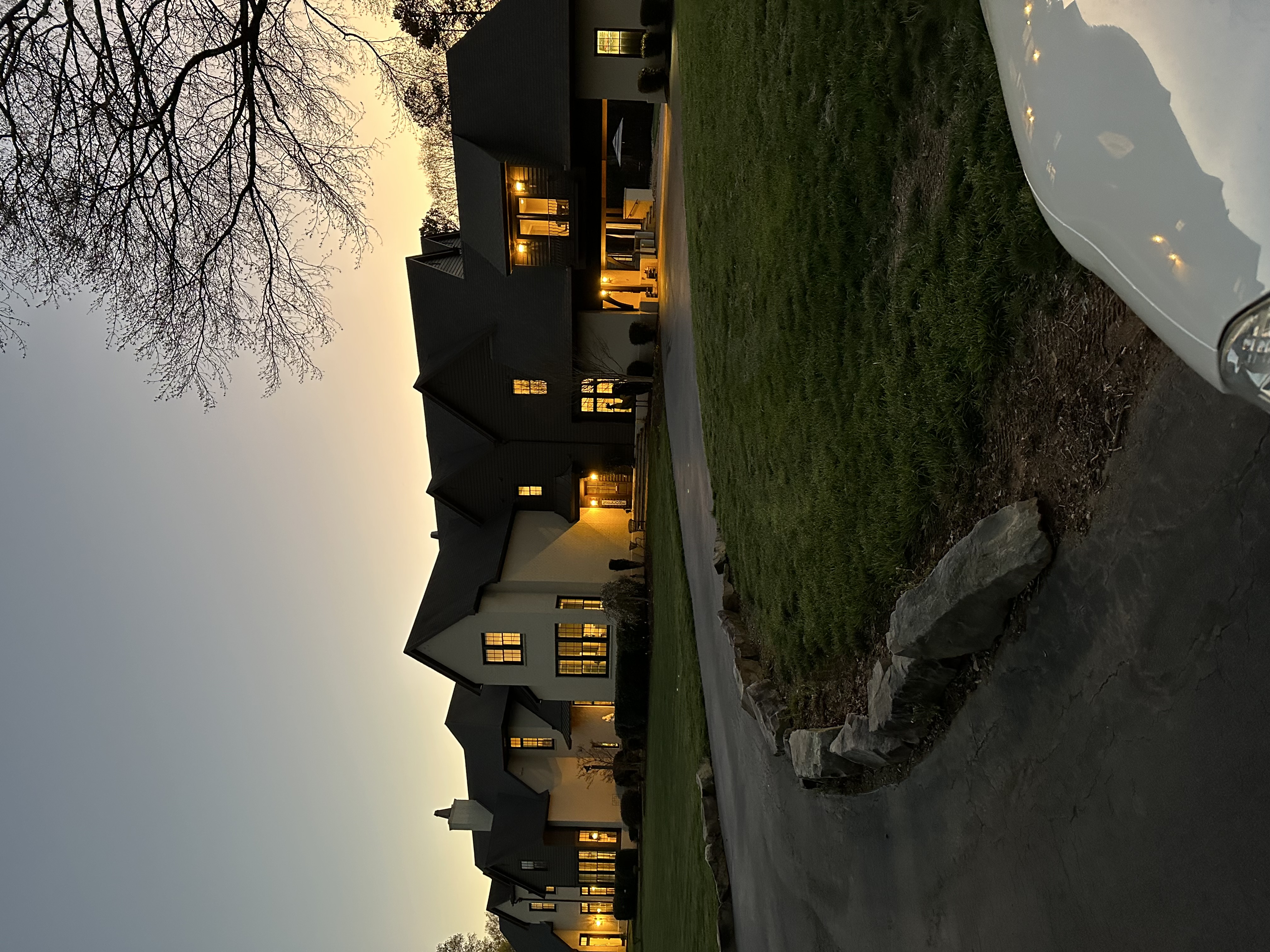 Modern luxury home at dusk with warm interior lighting and contemporary architecture in Davidson NC