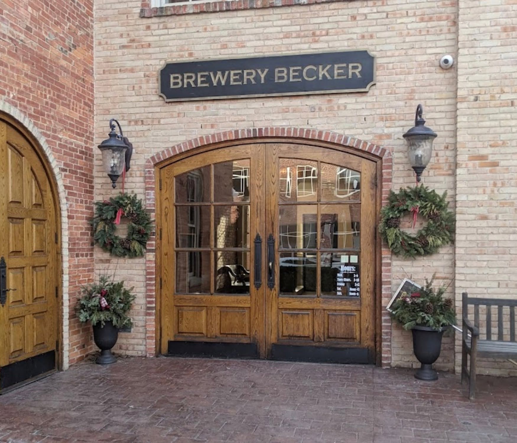 The historic three-story Italianate brick Western House building housing Brewery Becker on West Main Street in Brighton, Michigan, with warm golden-hour light and outdoor tables