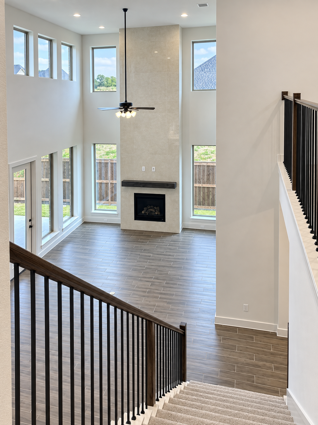Double-height living room with tall windows and a floor-to-ceiling fireplace, photographed during my Perry Homes visit in Celina.