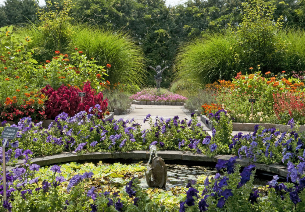 The demonstration garden at Applewood Estate, with raised beds of vegetables, herbs, and flowers arranged around a rustic wooden potting bench