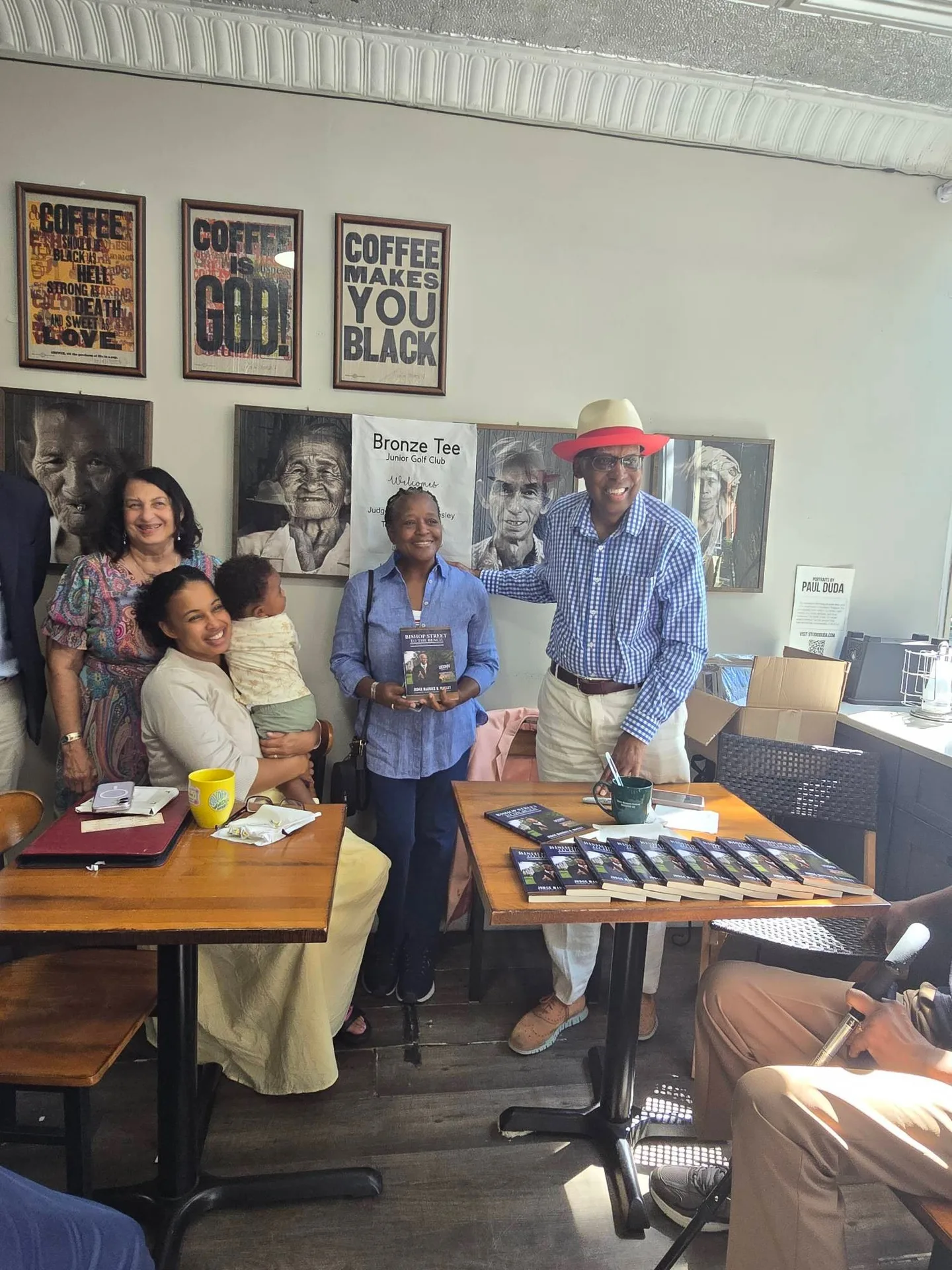 Author and guests at the book signing, with copies of the book on the table