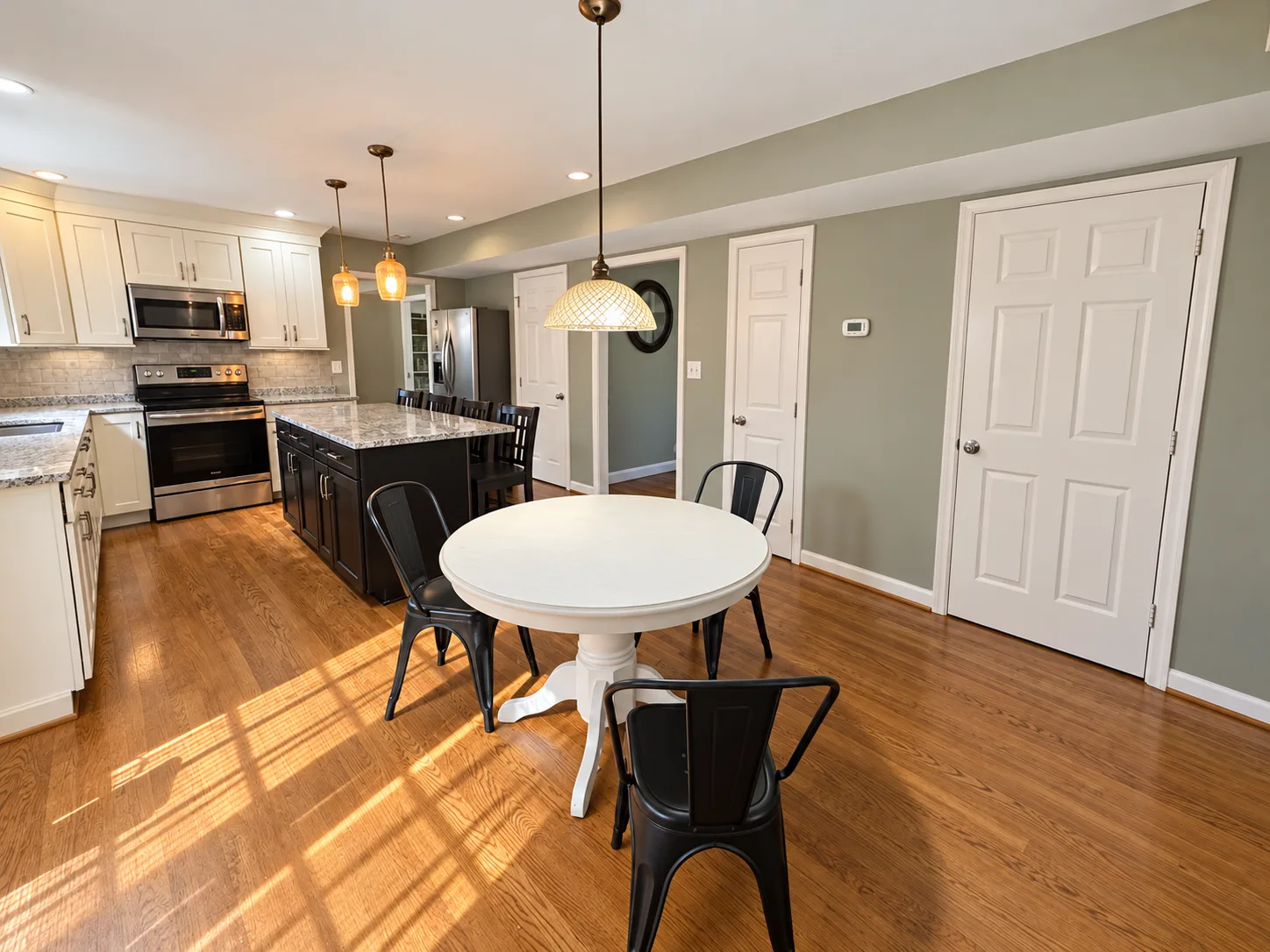 Kitchen and dining area with an island and a round dining table in the Summerwood short sale in Stafford VA