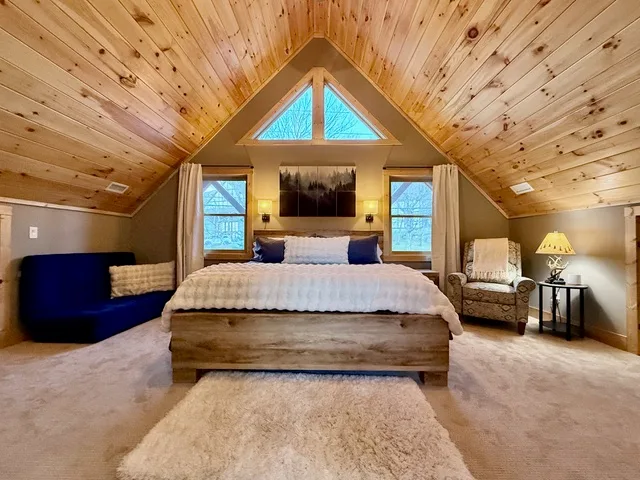 The bedroom with a vaulted ceiling