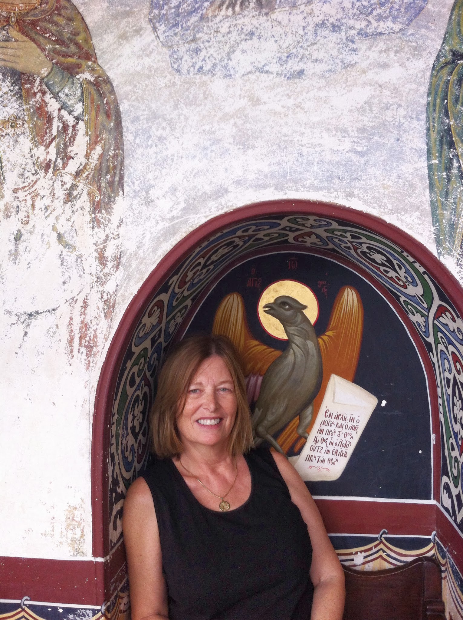 Carol standing beneath a painted arch at the Monastery of Saint John the Theologian on Patmos.