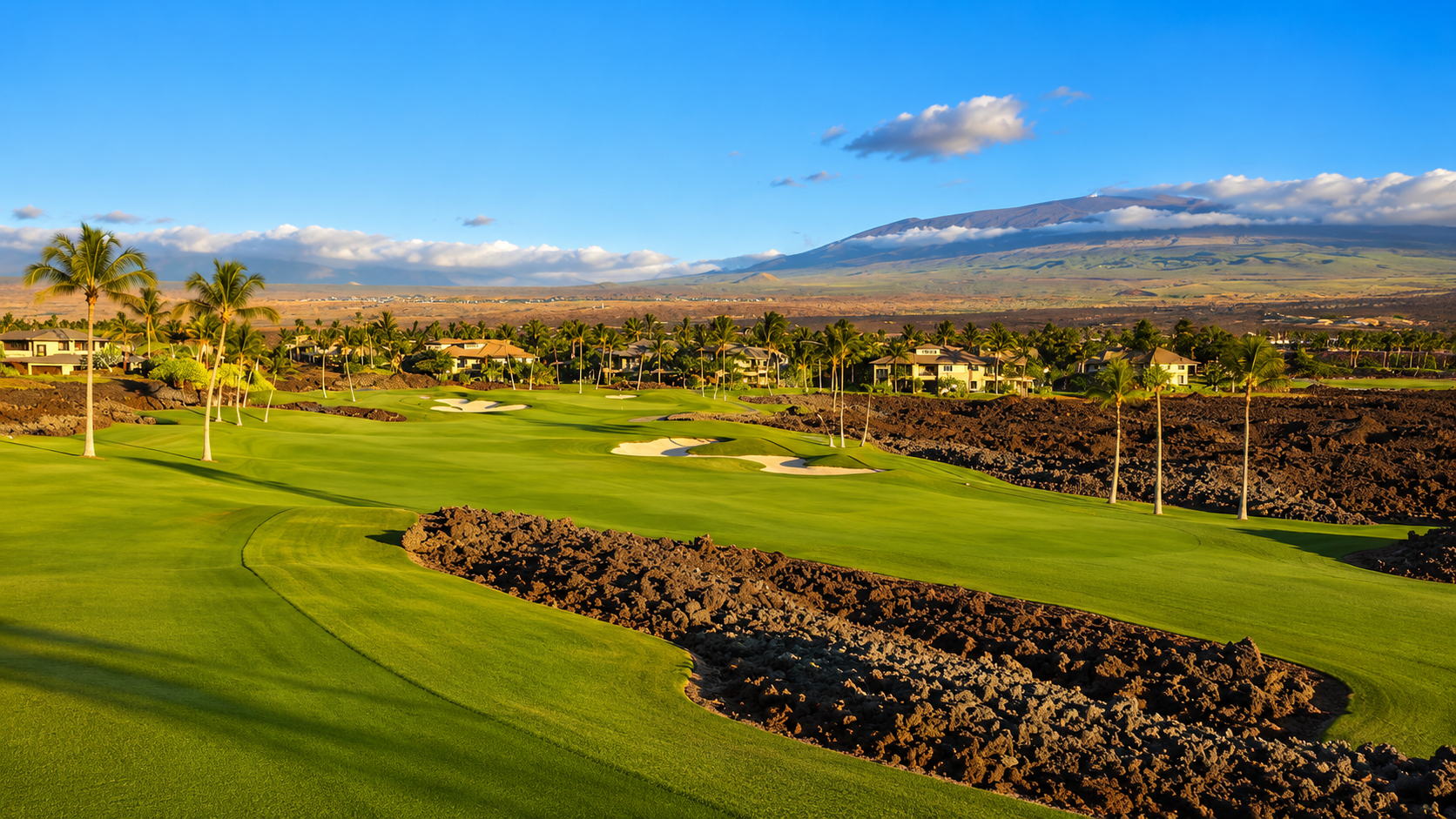 Golf course fairway with residential condominiums nestled among palm trees at Mauna Lani