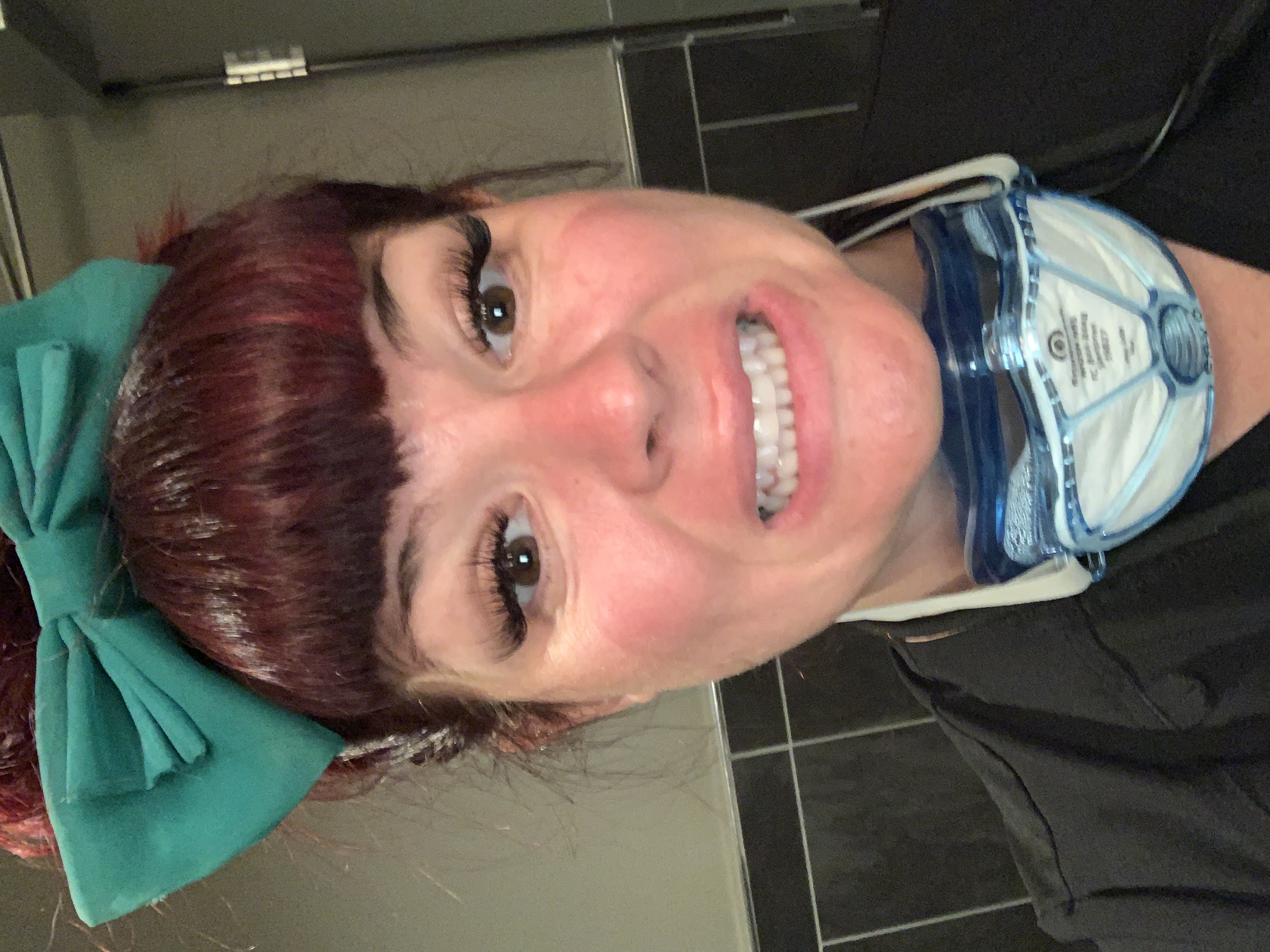 Samantha Medeiros with her N95 respirator pulled down below her chin, wearing her signature turquoise bow