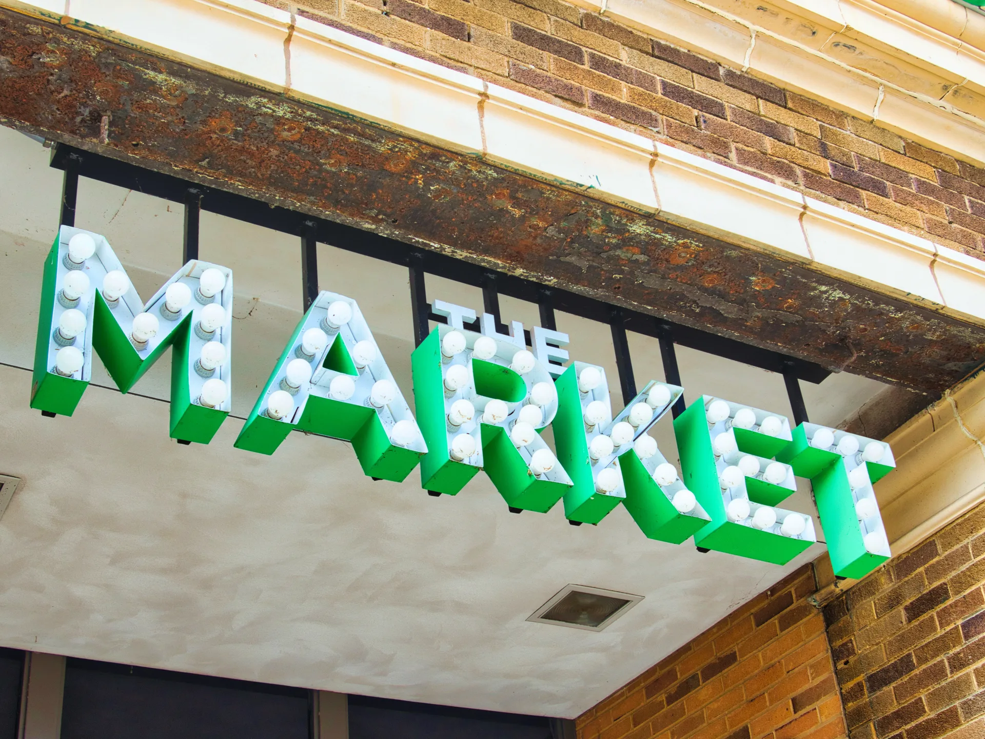 Bright green THE MARKET marquee sign with round bulbs on a historic brick building in Springfield Ohio
