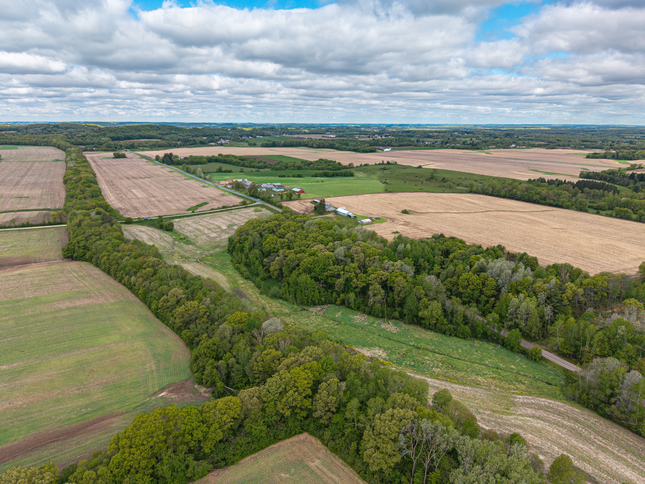 Aerial view of Wisconsin farmland with fields, tree belts, and a farmstead