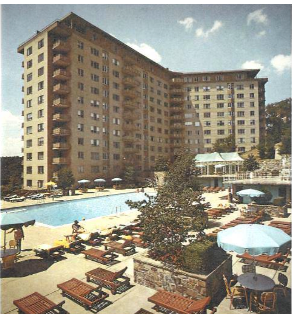The Colonnade, 2801 New Mexico Avenue NW, an L-shaped light brick apartment building with balconies and a pool in the foreground