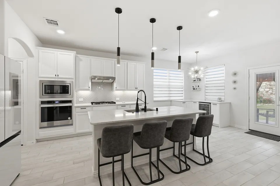 4126 Mountain Laurel Dr, Hickory Creek TX, modern kitchen with white cabinetry, large island, stainless appliances, and pendant lighting
