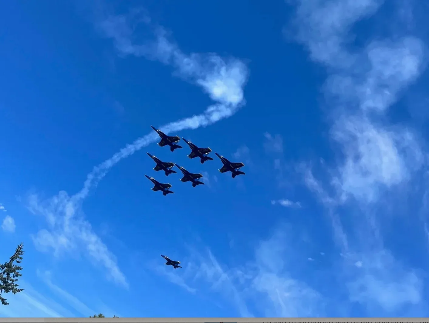 Six Blue Angels jets in tight formation with long white contrails against a bright blue sky with no ground clutter during Seafair weekend