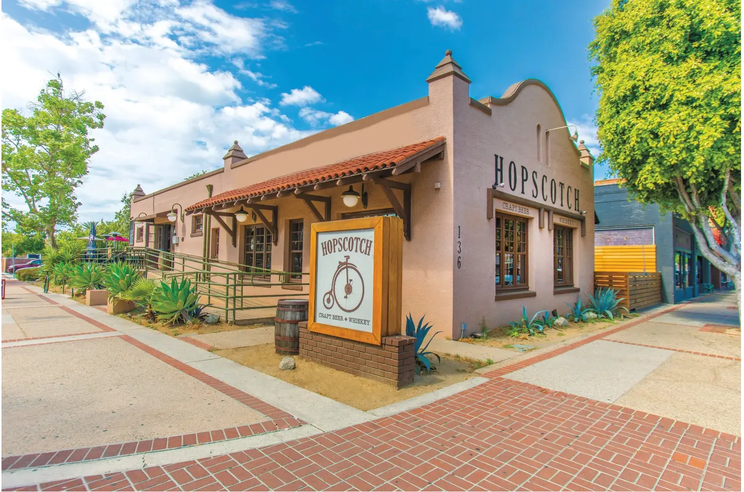 Exterior of HopScotch Tavern in Downtown Fullerton, showing the HOPSCOTCH lettering and the penny-farthing Craft Beer and Whiskey sign