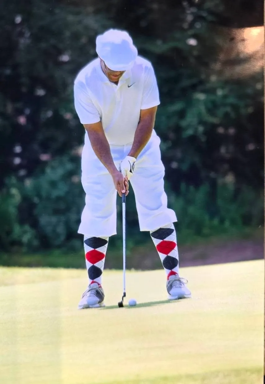 A golfer lines up a putt in classic Knickerbocker-style knickers and argyle socks at the Knickerbocker Golf Club Scholarship Tournament