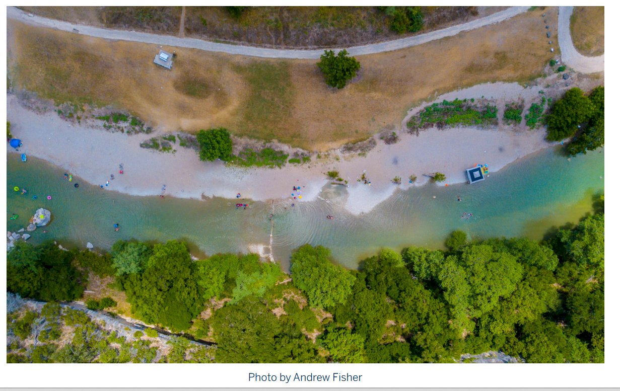 Aerial view of a tree-lined Hill Country river corridor near the Spring Branch area