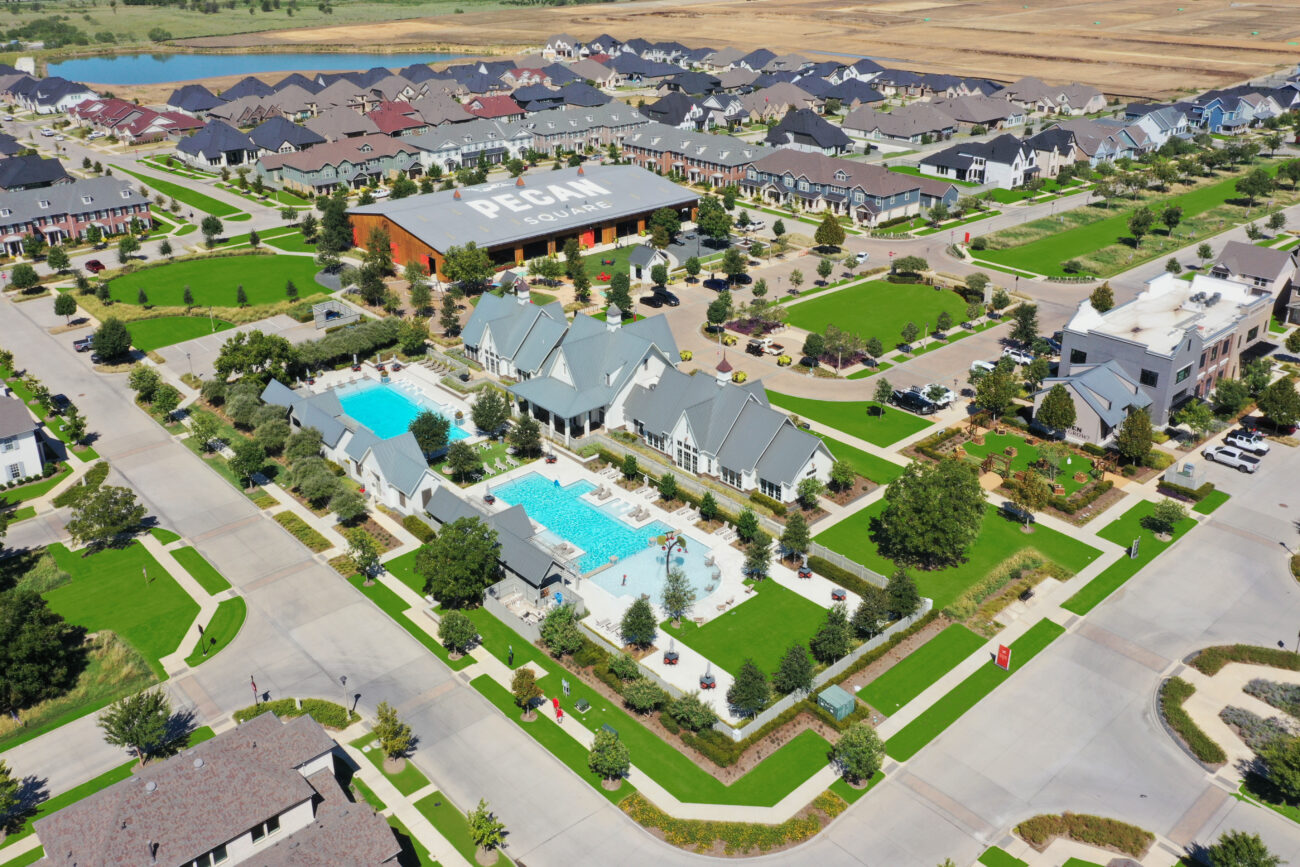 Wide aerial view of Pecan Square master-planned community in Northlake, Texas showing homes, pools, and amenity center