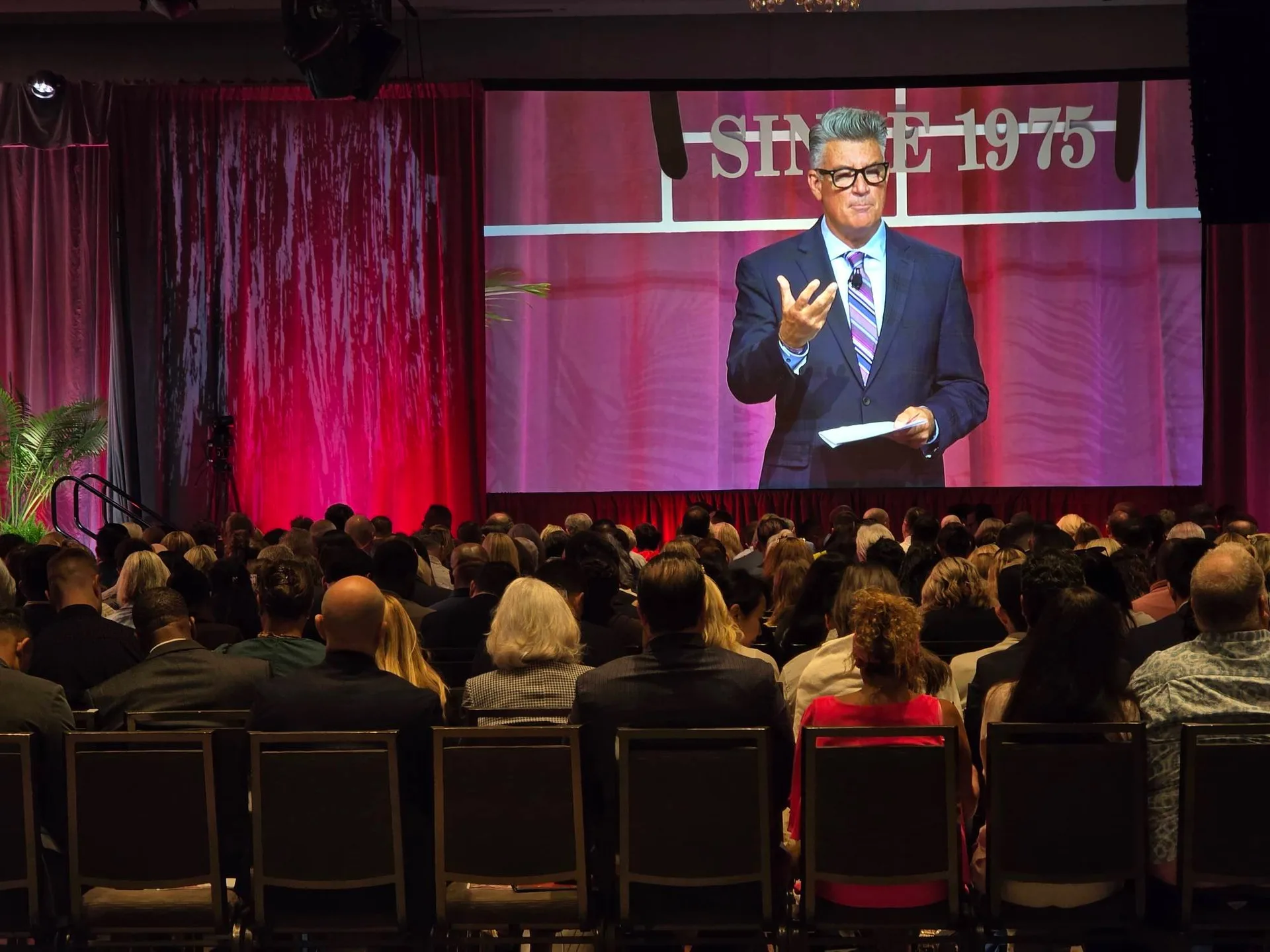 A keynote speaker on the big stage screen at the Mike Ferry 2026 Superstar Retreat at The Diplomat Beach Resort in Hollywood, Florida, with the SINCE 1975 backdrop