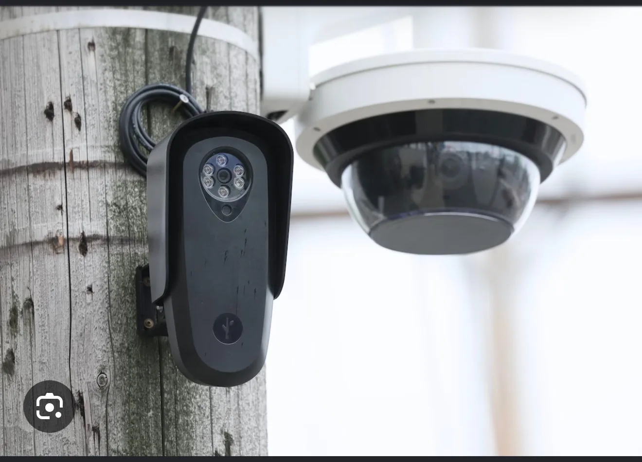 Surveillance cameras mounted on a utility pole overlooking a street