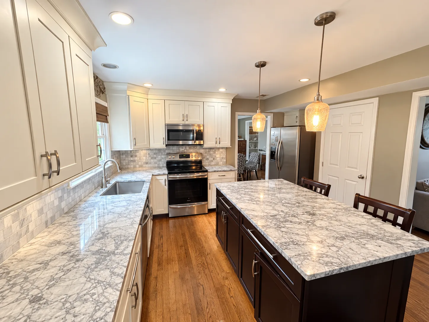 Kitchen with white cabinets, a dark island, and stainless steel appliances in the Summerwood short sale in Stafford VA